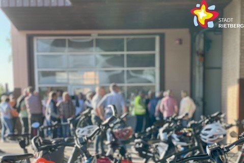Es sind Fahrradlenker zu sehen und Menschen im Hintergrund.