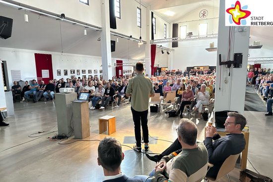 Blick in die Basilika des Bibeldorfes. Zu sehen sind Referneten des Abends im Vordergrund und das Publikum im Hintergrund.