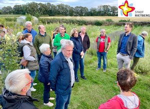 Dominik Schlüter erläutert mehreren Besuchern den Garten auf dem Hof Ecosphere.