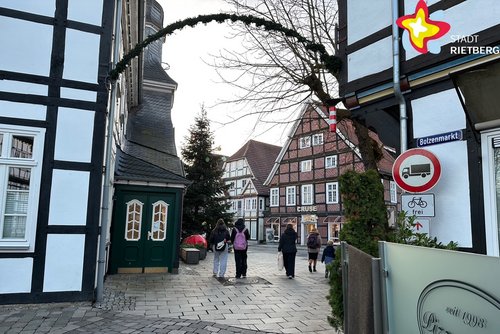 Das Foto zeigt die Durchfahrt zwischen historischem Rathaus und Pizzeria Due. Im Hintergrund sind ein großer geschmückter Tannenbaum und Fachwerkhäuser zu sehen.