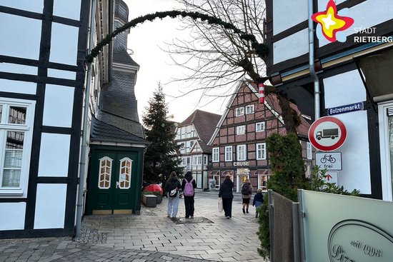 Das Foto zeigt die Durchfahrt zwischen historischem Rathaus und Pizzeria Due. Im Hintergrund sind ein großer geschmückter Tannenbaum und Fachwerkhäuser zu sehen.