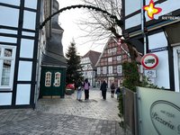 Das Foto zeigt die Durchfahrt zwischen historischem Rathaus und Pizzeria Due. Im Hintergrund sind ein großer geschmückter Tannenbaum und Fachwerkhäuser zu sehen.