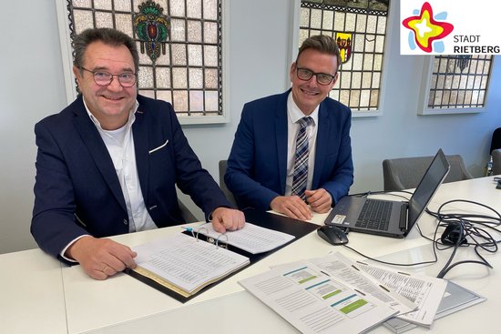 Beigeordneter Andreas Göke (links) und Bürgermeister Andreas Sunder sitzen in einem Besprechungsraum im Rathaus nebeneinander am Tisch und haben Unterlagen vor sich ausgebreitet.