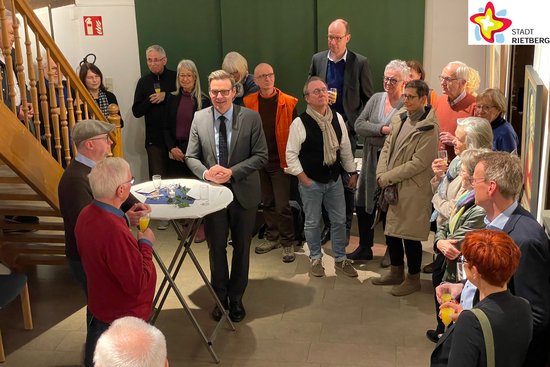 Bürgermeister Andreas Sunder steht inmitten mehrere Besucher im Kunsthaus Rietberg und hält eine Ansprache.