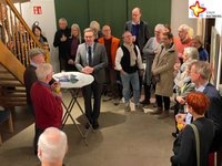 Bürgermeister Andreas Sunder steht inmitten mehrere Besucher im Kunsthaus Rietberg und hält eine Ansprache.