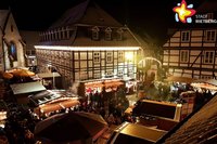 Aufsicht auf den Adventsmarkt, im Hintergrund das beleuchtete Rathaus.