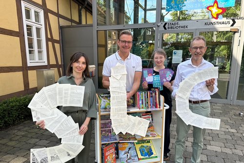 Die genannten Personen halten die Buchstaben SLC in den Händen und schauen in die Kamera.