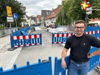 Jan Stephan steht auf der Rathausstraße an einer Absperrbacke und schaut in die Kamera.