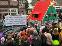 Karnevalswagen mit einer nachgebildeten Gaststätte aus Fachwerk. Der Giebel ist grün, das Dach rot.