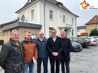 Die in der Bildzeile genannten Männer stehen vor dem alten Kolpinghaus in Neuenkirchen und schauen in die Kamera.