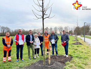 Bauhofmitarbeiter Alexander Speter, Westerwiehes Ortsvorsteher Detlev Hanemann, Bürgermeister Andreas Sunder, Baumpaten Petra und Marvin Busch, Bauhofmitarbeiter Martin Böcker, Baumpate Christian Schlingschröder und Tobias Keßler von der Abteilung Öffentliches Grün stehen im Halbkreis um eine frisch gepflanzte Linde.