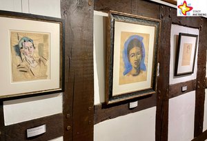 Zwischen den dunklen Fachwerk-Balken im Kunsthaus Rietberg hängen drei Bilder, die jeweils ein das gemalte Portrait eines Menschen zeigen.