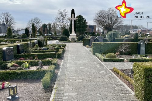 Das Foto zeigt Gräber (rechts und links) mit einem Gang in der Mitte. Das Wetter ist gut.
