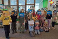 Kinder in der Stadtbibliothek Rietberg. Sie halten Bücher und Schilder hoch, auf denen die Worte stehen "Das haben wir gecheckt!"