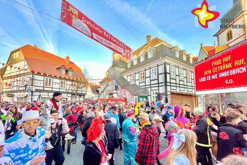 Unter blauem Himmel ist der Platz vor dem Historischen Rathaus mit bunt kostümierten Menschen gefüllt.
