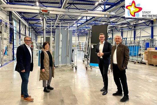 Johannes von Wenserski, Wirtschaftsförderin Renate Pörtner, Bürgermeister Andreas Sunder und Christoph Ruoff stehenh mitten in einer großen und hohen Produktionshalle und blicken in die Kamera.