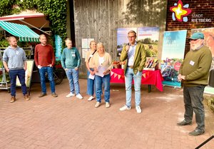 Thomas Bernasconi, Christoph, Johan und Lisa Wiesbrock, Magdalene Mertens-Wiesbrock, Andreas Sunder und Josef Wiesbrock stehen nebeneinander vor einem hölzenern Scheunentor.