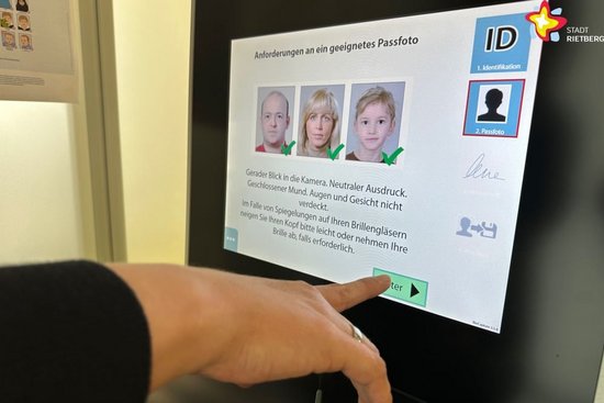 Eine Hand bedient das Touchscreen des digitalen Fotoservice-Punktes.