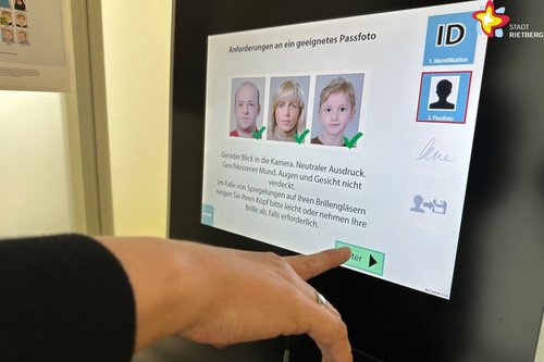 Eine Hand bedient das Touchscreen des digitalen Fotoservice-Punktes.