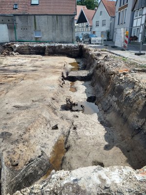 Ein flacher Graben ist an der Seite eines Grundstücks neben der Straße zu erkennen