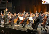 Auf der Bühne der Cultura spielt sitzend die Nordwestdeutsche Philharmonie unter der Leitung von David Marlow.