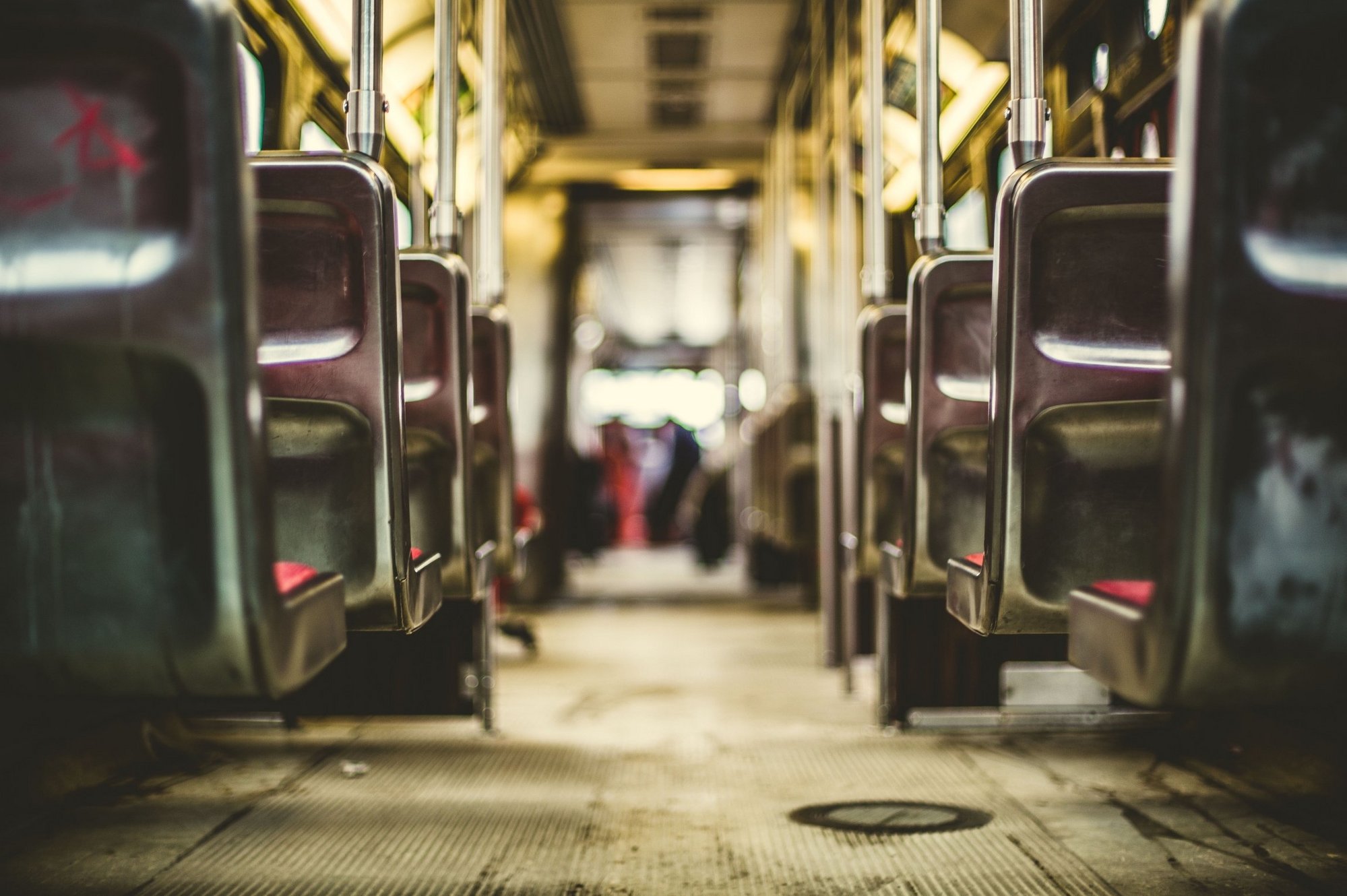 In eionem Bus des öffentlichen Nahverkehrs wird von hinten ein Blick auf die leeren Sitze gewährt.