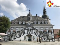 Das Historische Rathaus von Rietberg bei Sonnenschein. Die Aufnahme ist von der Rathausstraße aus gemacht worden. Der Himmel im Hintergrund ist blau mit einzelnen Wolken.