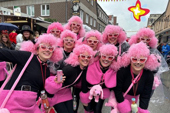 Diese Truppe ist als Pudeldamen verkleidet, mit rosa Perücken auf dem Kopf.