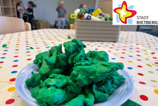 Ein Teller grüner Knete auf dem Spieltisch eines Kindergartens symbolisiert die Platzvergabe für das neue Kindergartenjahr.