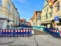 Straßensperren verdeutlichen, dass hier keine Durchfahrt möglich ist. Rechts im Bild sieht man eine unfertige Straße.