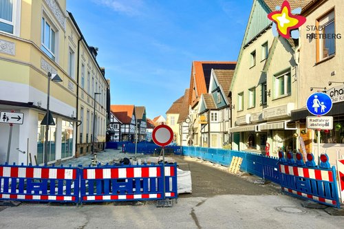 Straßensperren verdeutlichen, dass hier keine Durchfahrt möglich ist. Rechts im Bild sieht man eine unfertige Straße.