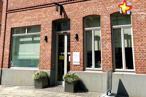 Das Foto zeigt die städtische Touristikinformation an der Rathausstraße von außen. Es ist ein rotes Backsteingebäude.
