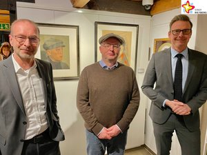 Frank Ehlebracht von der Sparkassenstiftung, Kunsthändler Jan Henneken und Bürgermeister Andreas Sunder stehen im Kunsthaus Rietberg vor einigen Gemälden und blicken in die Kamera.