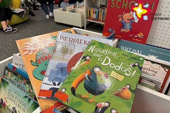 Mehrere bunte Kinderbücher liegen aufeinander gestapelt.