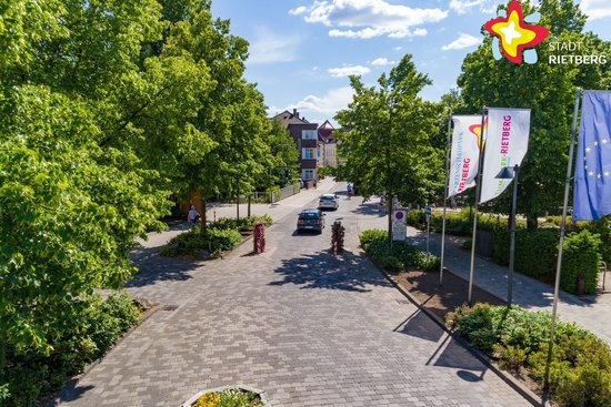 Zu sehen ist eine Luftaufnahme von einem Teil der Rathausstraße im Bereich Nordtor. man sieht in der Mitte die Straße, links Bäume und rechts Fahnen.