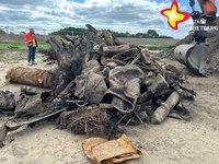 Sperriger alter und verrosteter Müll liegt auf einem Haufen. Dahinter steht ein Bagger.
