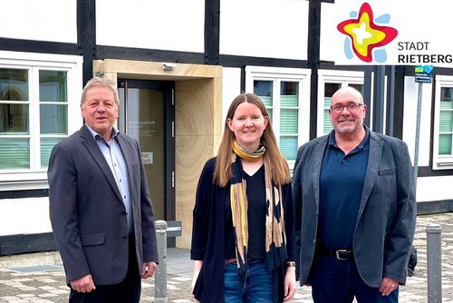 Wilfried Dörhoff, Lisa Henke und Thomas Krüger stehen vor dem Verwaltungsgebäude Rügenstraße 1 und werben für die kostenfreie Wohnberatung.