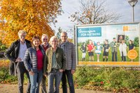 Marcus Miesler vom Vorstand, Doris Vogel und Heinrich Rasche aus der Geschäftsstelle der Bürgerstiftung sowie Anja Rodenbeck und Norbert Laumeier vom Kuratorium stehen vor einem neuen Werbeplakat der Bürgerstiftung, welches sieben Vereinsvertreter aus sieben Stadtteilen zeigt.