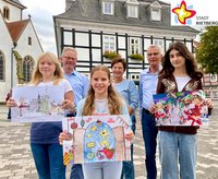 Annika Timmer, Heiner Rasche, Gioia Sofia Frau, Doris Vogel, Norbert Laumeier und Shushan Kazarian zeigen vor dem Historischen Rathaus stehend die Gewinnerbilder des Adventskalender-Malwettbewerbs.