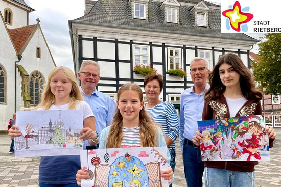 Annika Timmer, Heiner Rasche, Gioia Sofia Frau, Doris Vogel, Norbert Laumeier und Shushan Kazarian zeigen vor dem Historischen Rathaus stehend die Gewinnerbilder des Adventskalender-Malwettbewerbs.