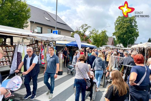 Menschen schlendern an Verkaufsständen vorbei.