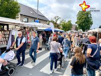 Menschen schlendern an Verkaufsständen vorbei.