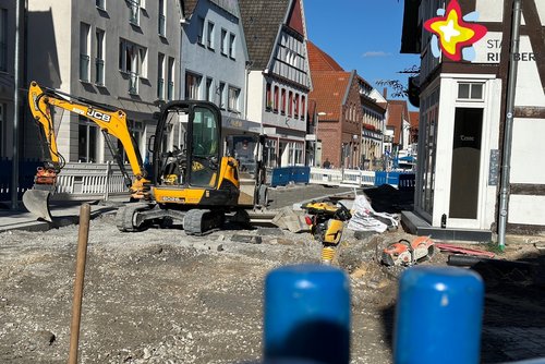 Baustelle auf der Rathausstraße. Ein Bagger steht in der Mitte des Fotos.