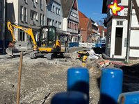 Baustelle auf der Rathausstraße. Ein Bagger steht in der Mitte des Fotos.