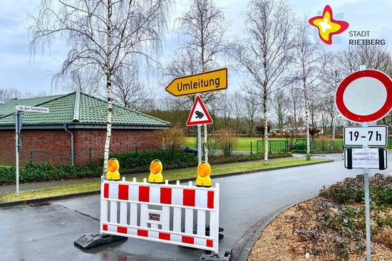 Eine Absperrbake sowie ein Hinweisschild für eine Umleitung stehen an der Einfahrt der Straße An den Teichwiesen.