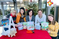 Die Mitarbeiterinnen der Stadtbibliothek Rietberg – Margot Reinkemeier, Filiz Akgül, Bärbel Reich, Julia Bröckling und Jennifer Bader – zeigen vor einem geschmückten Weihnachtsbaum ihre Lieblings-Kinderbücher zum Thema Weihnachten.