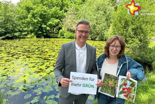 Die genannten Personen stehen vor einem Teich im Klostergarten. Er ist bedeckt mit vielen Seerosen. Rundherum stehen grüne Bäume.