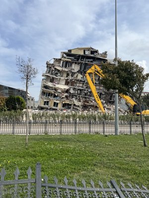 Ein Kran steht vor einem schwer beschädigten Haus.